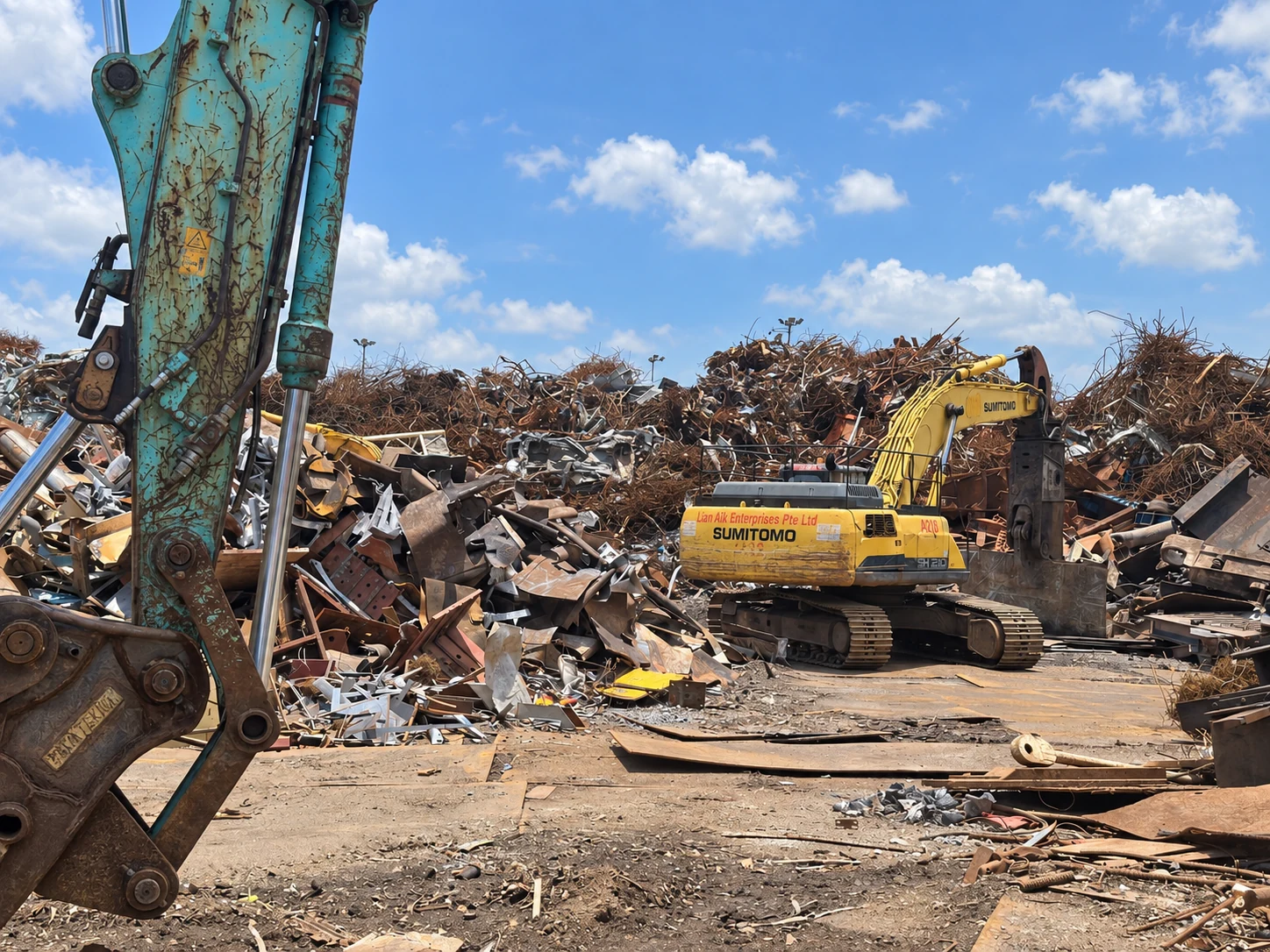 Lian Aik excavator working among recovered metal at the yard