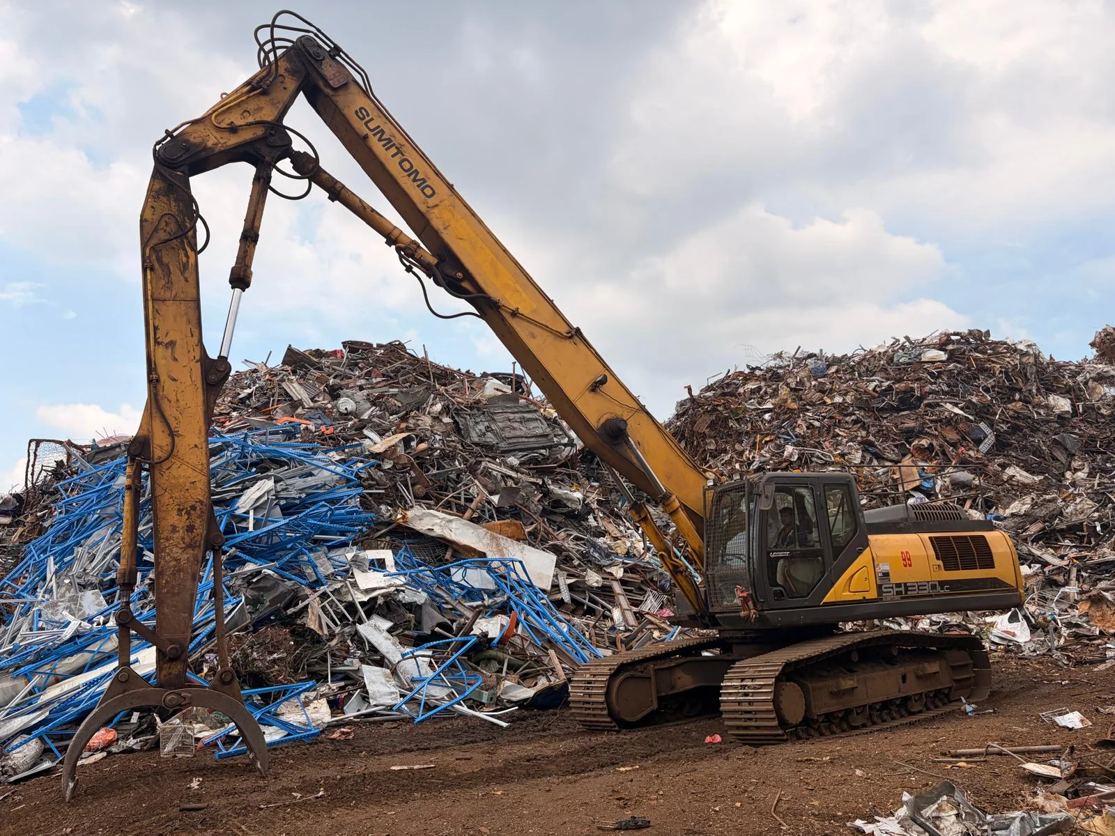Grapple excavator handling dismantled metal